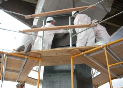 Workers applying Structural Strengthening vinyl sheets to pipe