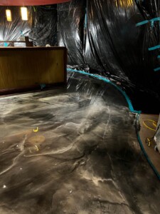 Installation of dark gray resinous flooring in progress