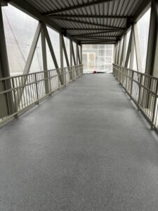 View of the Bellevue Square Skywalk with gray resinous flooring under a covered walkway.